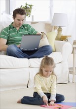 Father and daughter relaxing in livingroom. Date : 2007