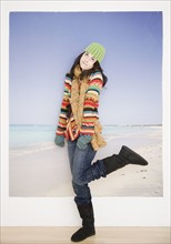 Woman in winter clothing in front of beach picture. Date : 2007