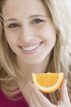 Close up of woman holding orange wedge. Date : 2007