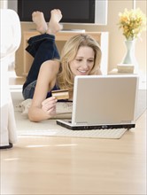 Woman shopping online on floor. Date : 2007