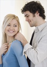 Man putting necklace on girlfriend. Date : 2007