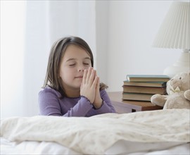 Girl praying next to bed. Date : 2006