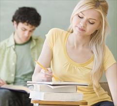 Woman writing at desk in classroom. Date : 2007