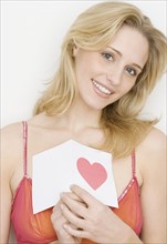 Portrait of woman holding card with heart. Date : 2007