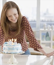 Woman smiling at birthday cake. Date : 2006