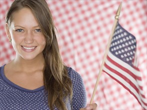 Young woman smiling and holding American flag. Date : 2006