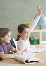 Girl raising hand in classroom. Date : 2006