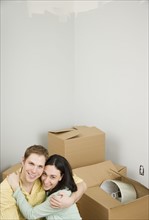 Couple hugging next to boxes in new house. Date : 2006