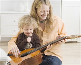 Mother and child playing with guitar. Date : 2006