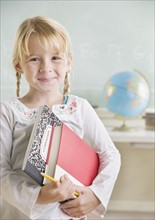 Young girl holding school books and smiling. Date : 2006