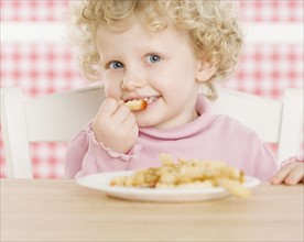 Female child eating French fries. Date : 2006