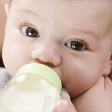 Close up of baby drinking from bottle. Date : 2006