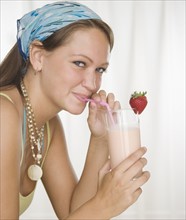Young woman drinking smoothie with straw. Date : 2006