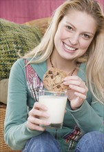 Young woman enjoying a cookie and milk. Date : 2006