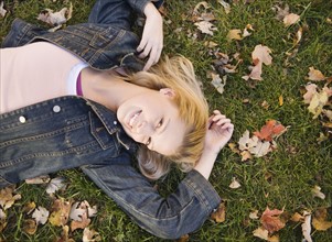 Woman lying in grass on a fall day. Date : 2006