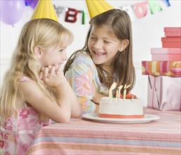 Young sisters with birthday cake at table. Date : 2006
