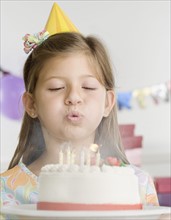 Young girl blowing out candles on cake. Date : 2006