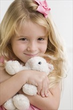 Close up of young girl hugging stuffed animal. Date : 2006