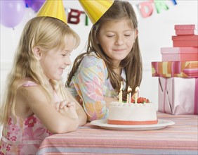 Young sisters with birthday cake at table. Date : 2006