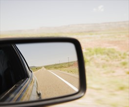 Road reflected in car side mirror. Date : 2006
