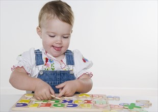 Female toddler playing with a puzzle. Date : 2006