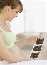 Pregnant woman looking at ultrasound printout. Date : 2007