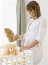 Pregnant woman smiling at teddy bear. Date : 2007