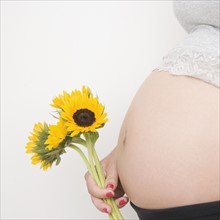 Pregnant woman holding sunflowers. Date : 2007