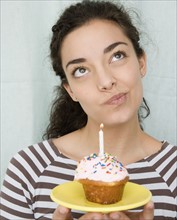 Woman holding cupcake with candle. Date : 2007