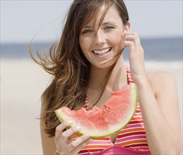 Woman eating watermelon at beach. Date : 2007