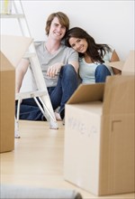 Couple sitting next to moving boxes. Date : 2007