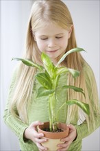 Girl holding potted plant. Date : 2007