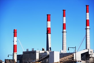 Factory with smoke stacks under blue sky. Date : 2007