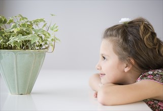 Girl looking at potted plant. Date : 2007
