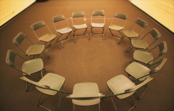 Empty folding chairs in circle. Date : 2007