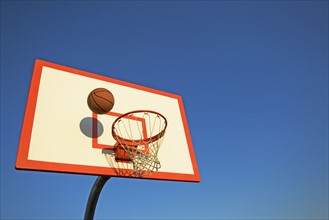 Basketball in mid air over hoop. Date : 2007