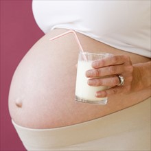 Pregnant woman holding glass of milk. Date : 2007