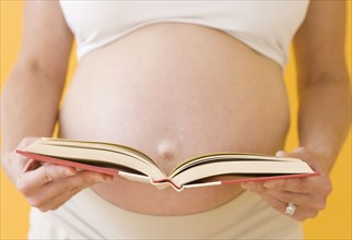 Pregnant woman holding open book. Date : 2007