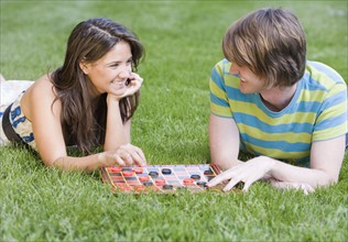 Couple playing checkers in grass. Date : 2007