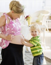 Baby touching mother’s pregnant belly. Date : 2007
