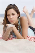 Woman blowing on sand in hands. Date : 2007