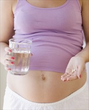 Pregnant woman taking vitamins. Date : 2007