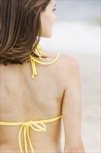 Woman in bikini with sand on back. Date : 2007