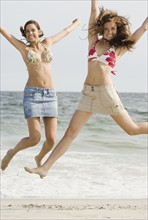 Young women jumping at beach. Date : 2007