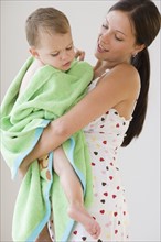 Mother holding baby wrapped in towel. Date : 2007