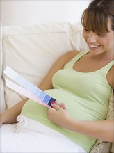 Pregnant woman looking at paint swatches. Date : 2007