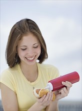 Woman putting ketchup on hotdog. Date : 2007