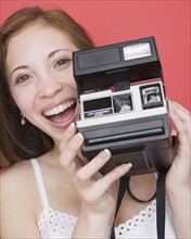 Woman holding instant camera. Date : 2007
