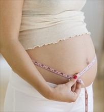 Pregnant woman measuring belly. Date : 2007
