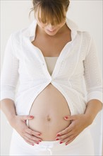 Pregnant woman smiling at belly. Date : 2007